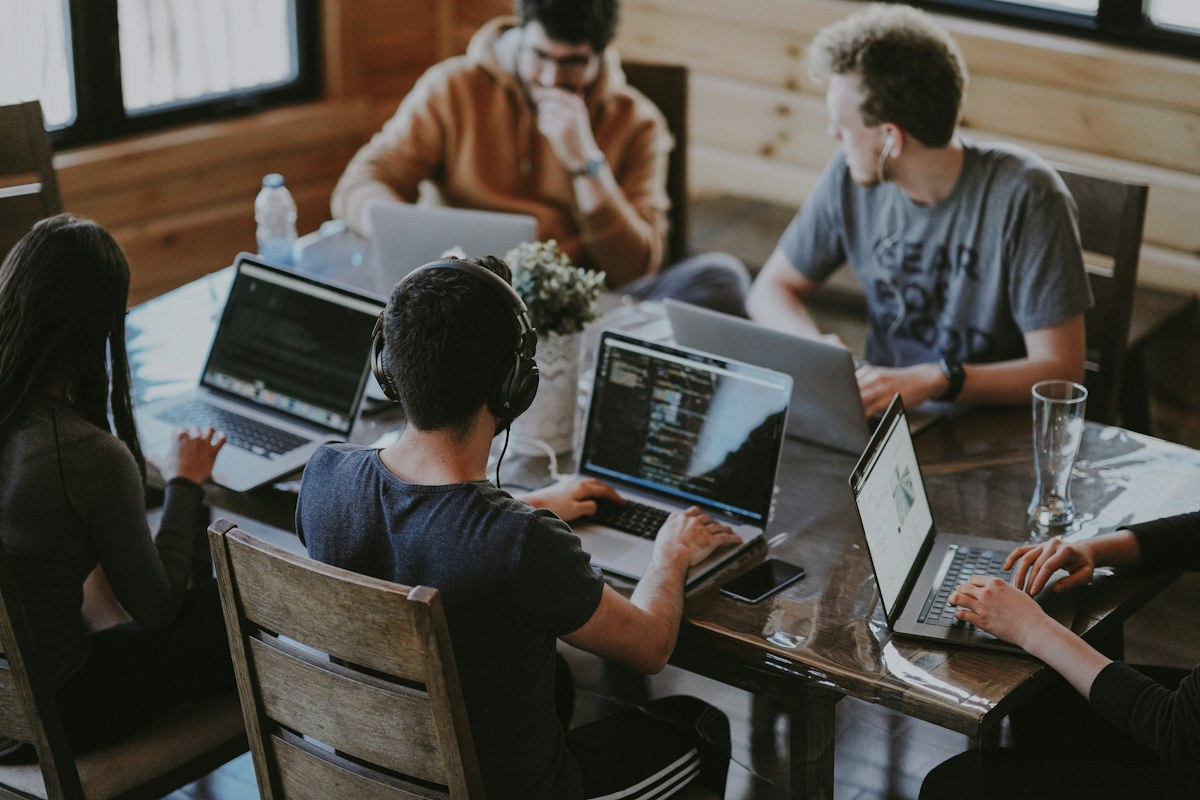 Colleagues gather around computers in an office meeting to review engineering work.