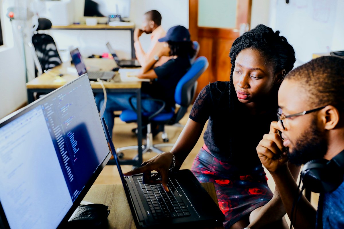 A small team works at laptops in a bright shared office.